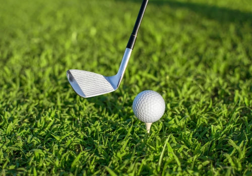 Custom-stamped golf ball placed on a lush golf fairway with distant green and scenic course backdrop