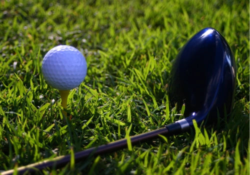 Close-up of a personalized golf ball on well-maintained golf course turf, showcasing crisp stamping details