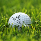 Person using a personalized golf ball stamp to imprint their initials onto a white golf ball.
